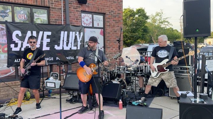 Save July mid-set under red and blue stage lights