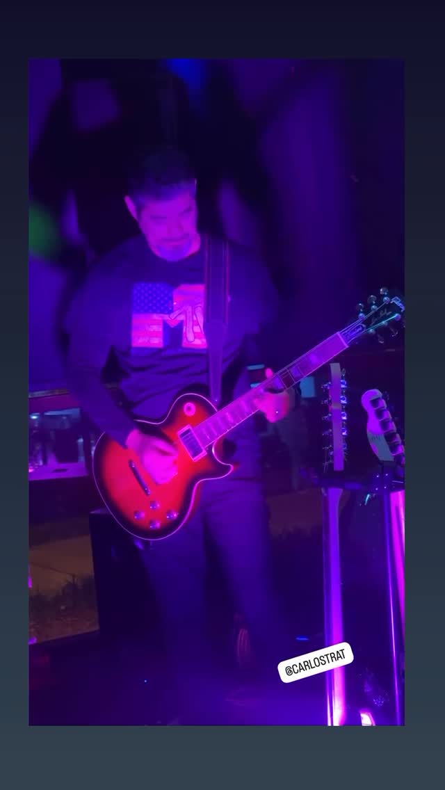 Guitarist taking a solo on a sunburst Les Paul in deep purple light