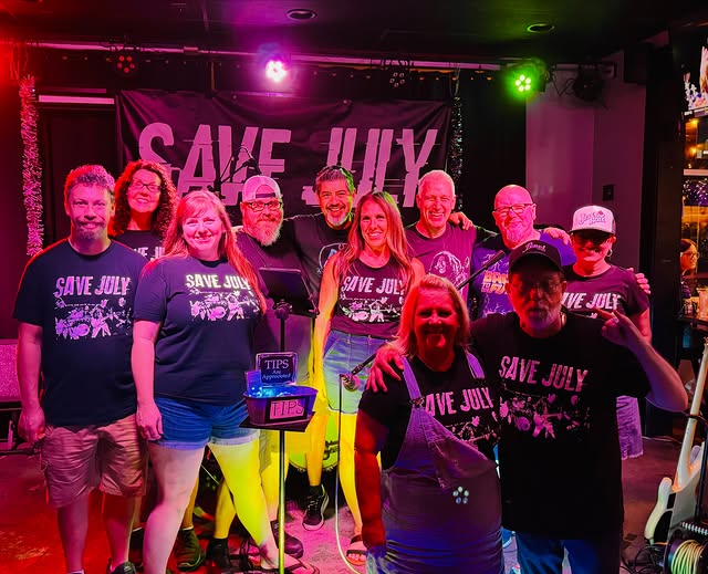 The band and a crowd in Save July shirts after a show at Moochie's Tavern